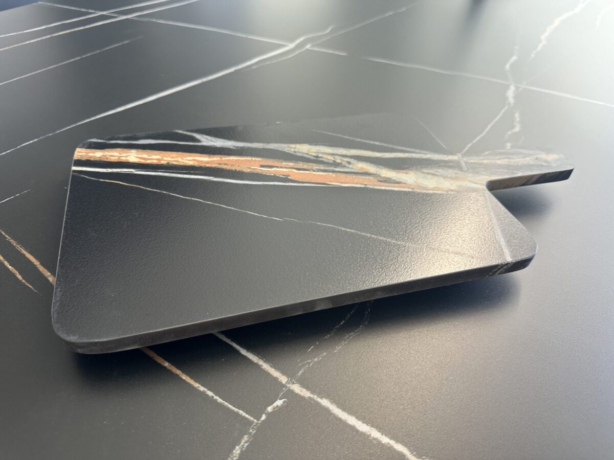 Marble kitchen countertop with a wooden cutting board.