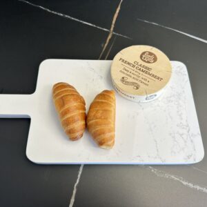 Two croissants and camembert on a marble cutting board.
