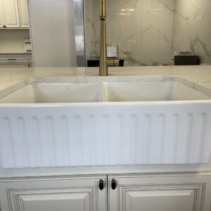 White farmhouse sink in a modern kitchen setting.