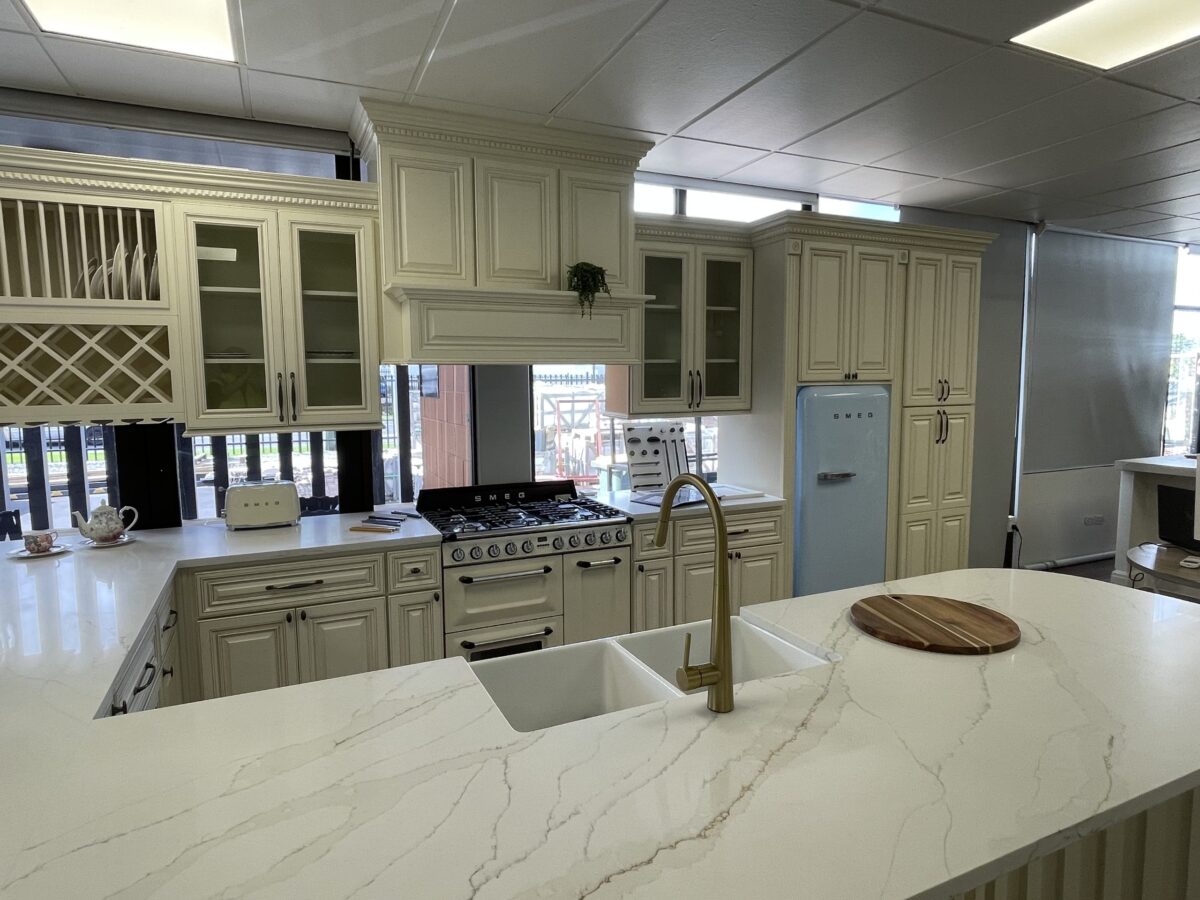 Modern kitchen with marble island, vintage fridge, and white cabinetry.