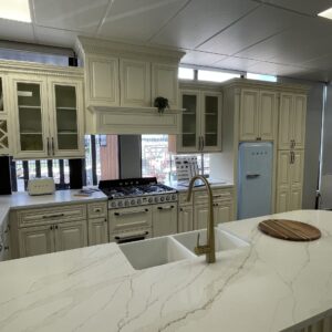 Modern kitchen with marble island, vintage fridge, and white cabinetry.