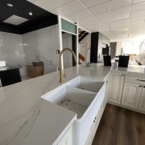Modern kitchen with marble countertops and farmhouse sink.