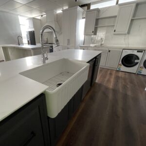 Modern kitchen with white countertops and farmhouse sink.