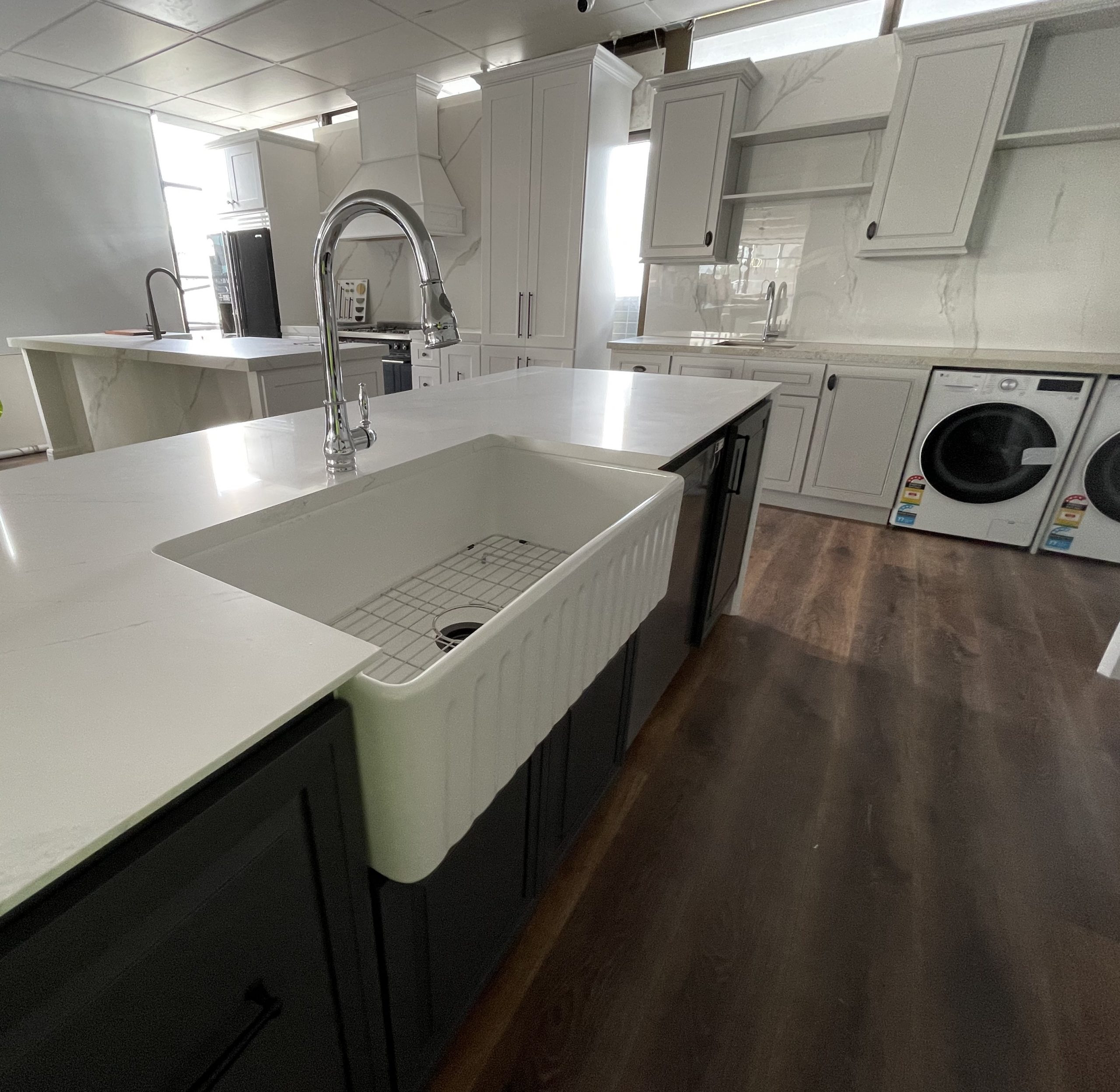 Modern kitchen with white countertops and farmhouse sink.
