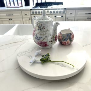 Floral teapot and creamer on marble kitchen counter.