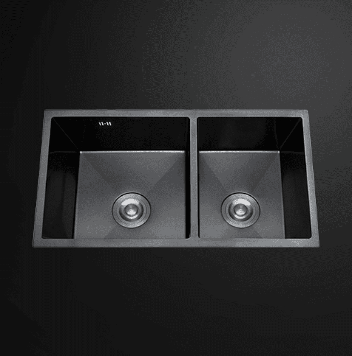 Double bowl black kitchen sink on dark background.