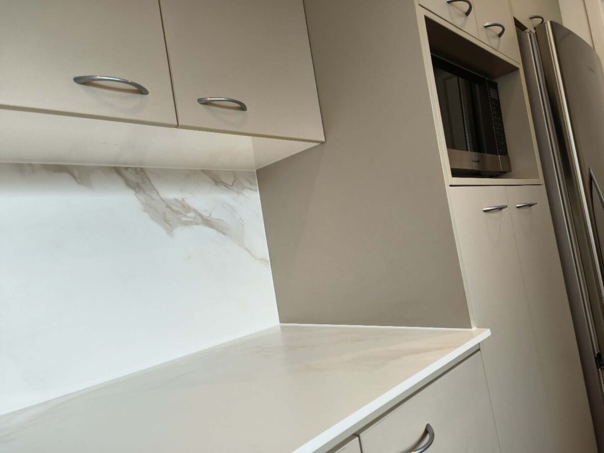 Modern kitchen with marble backsplash and stainless steel appliances.