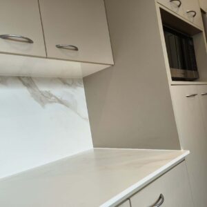 Modern kitchen with marble backsplash and stainless steel appliances.