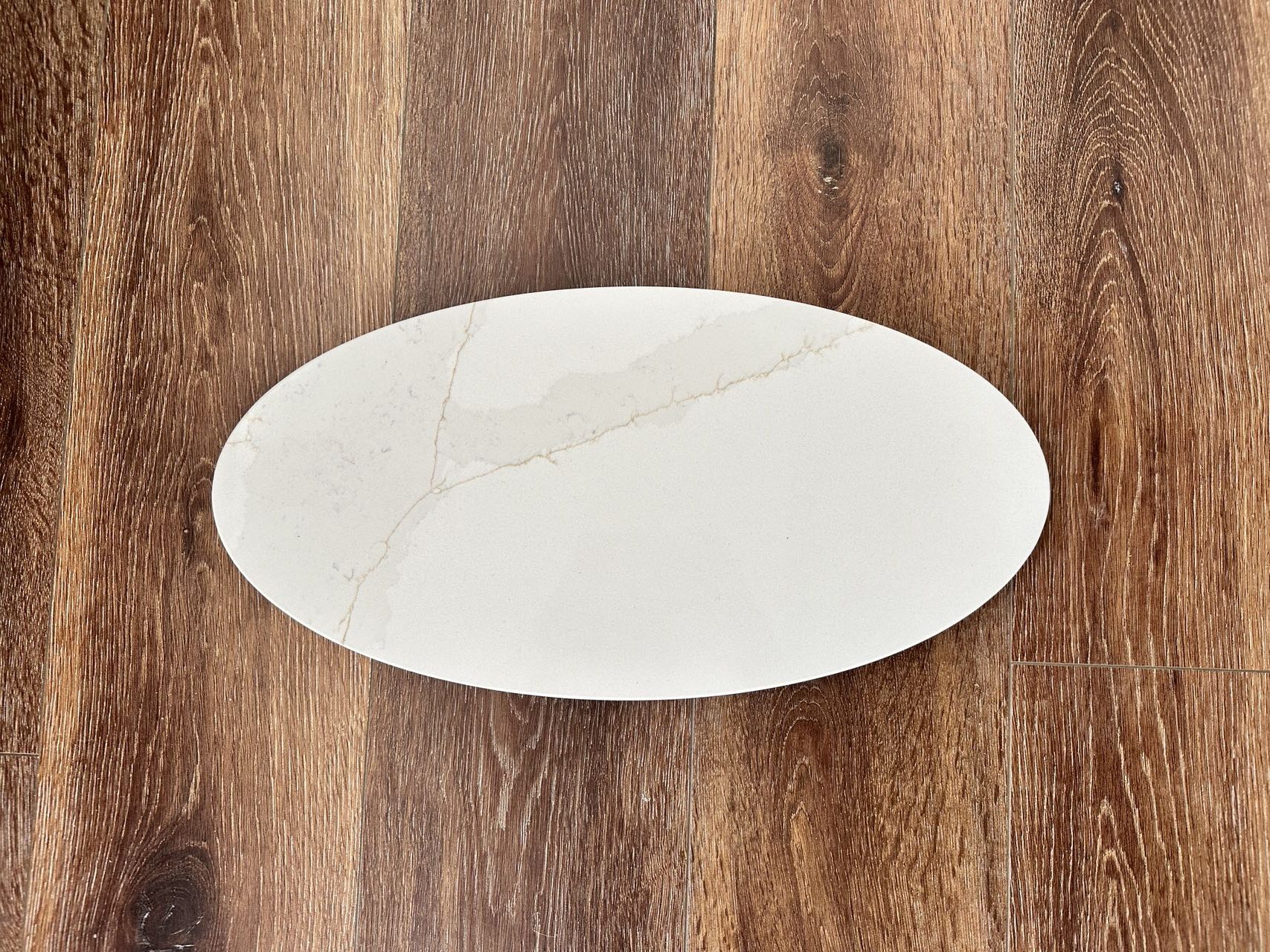Oval marble plate on wooden floor.
