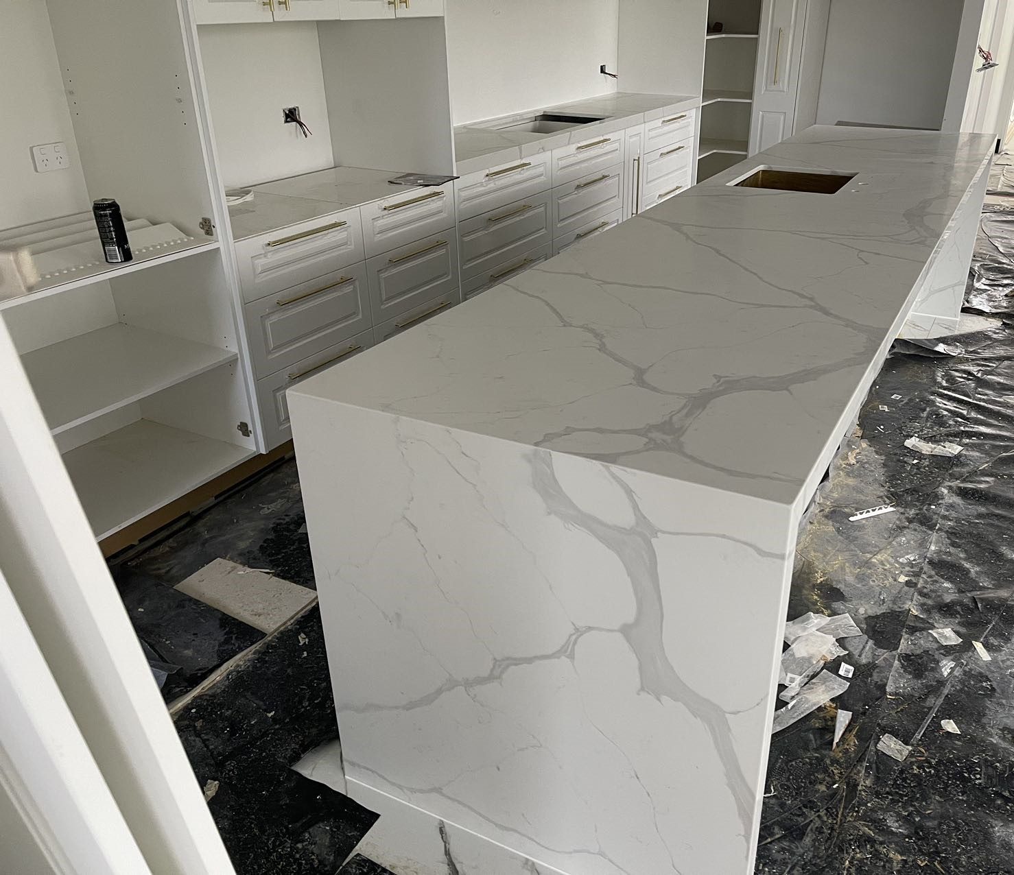 Modern kitchen with marble island countertop under construction.
