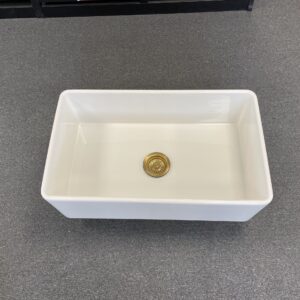 White rectangular kitchen sink on a gray countertop.