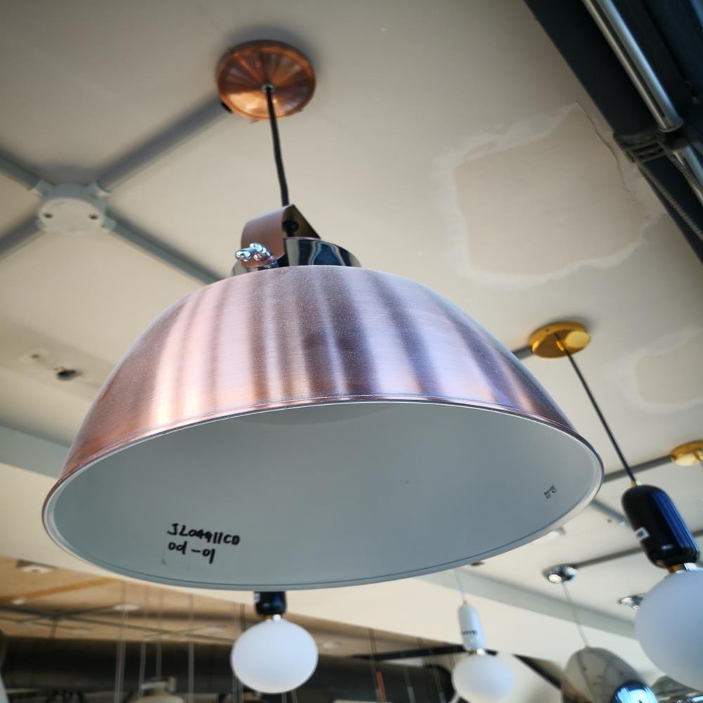 Hanging copper pendant light in modern kitchen showroom.