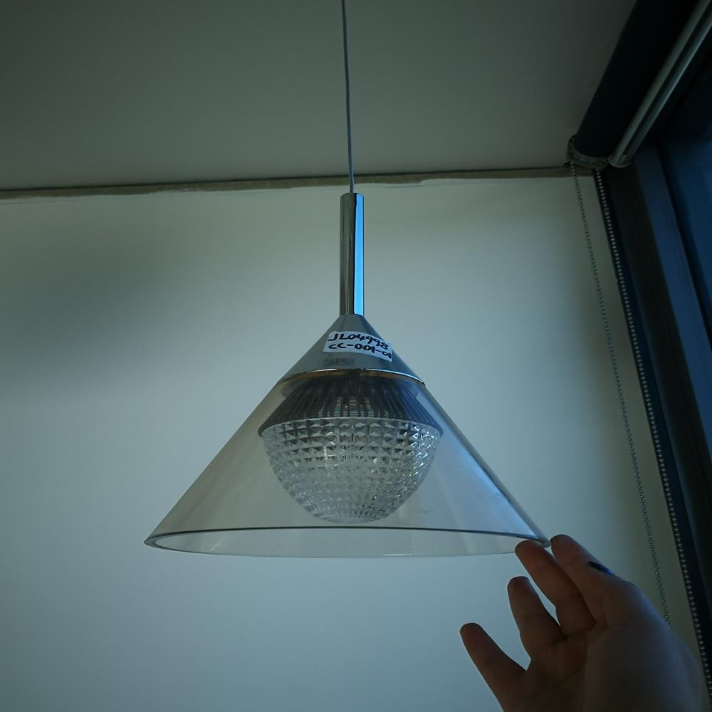 Hanging cone-shaped light fixture with a hand reaching towards it.