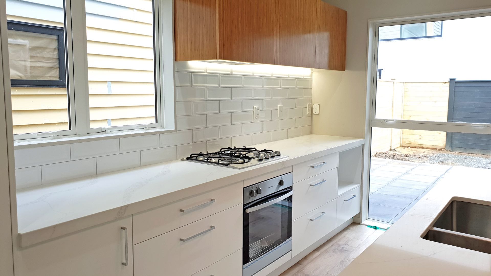 Modern kitchen with marble countertop and wooden cabinets.