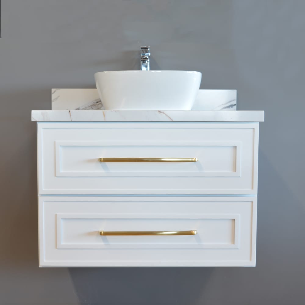 Wall-mounted white vanity with marble top, gold handles, and above-counter basin