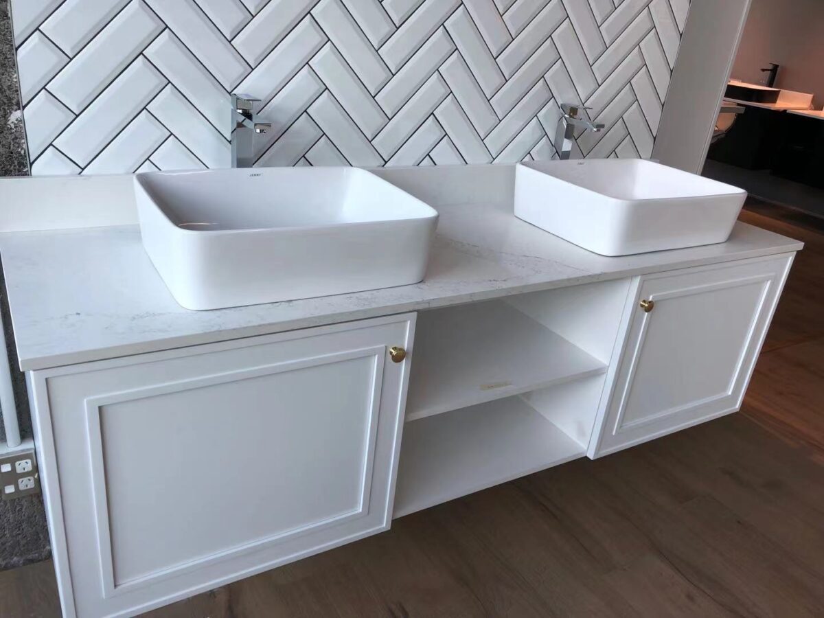 White double sink vanity with herringbone tile backsplash.