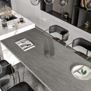 Modern kitchen with marble countertop and black chairs.