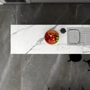 Marble kitchen countertop with fruit bowl and sink, viewed from above.