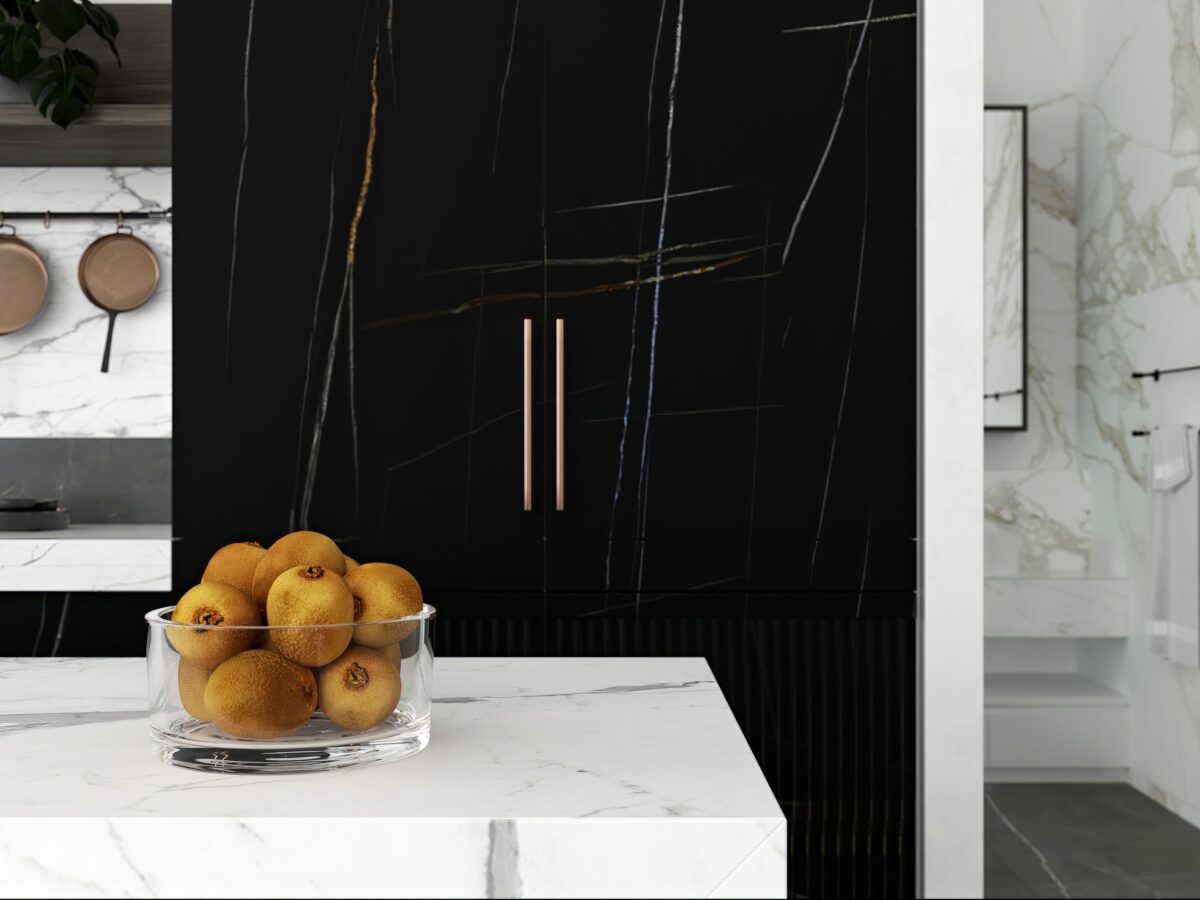 Bowl of oranges on marble counter in modern kitchen.