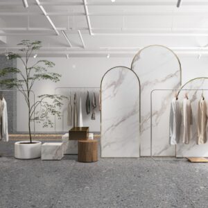 Minimalist clothing store interior with marble dividers and hanging garments.